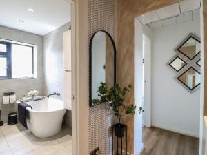 a bathroom with a tub and a sink and a mirror at 57 Howden Avenue in Doncaster