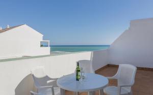 a table and chairs on a balcony with the ocean at Apartamentos Playa Barbate in Barbate