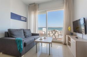a living room with a couch and a large window at Apartamentos Playa Barbate in Barbate
