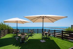 a group of tables and chairs with umbrellas at Summer Vibe Costinesti in Costinesti