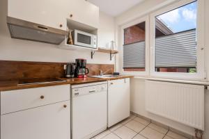 a kitchen with white cabinets and a microwave at Ferienhaus nahe Uni Lueneburg in Lüneburg