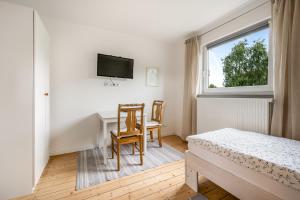 a bedroom with a desk and a bed and a window at Ferienhaus nahe Uni Lueneburg in Lüneburg