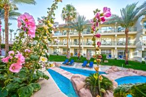 a resort with a swimming pool and flowers at Xperience Sea Breeze Resort in Sharm El Sheikh