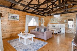 a living room with a bed and a couch and a table at Abendruhe Lodge in Pretoria
