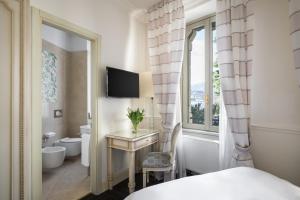 a bedroom with a bed and a desk and a window at Albergo Terminus in Como +68 photos