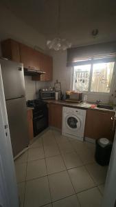 a kitchen with a refrigerator and a washing machine at self checkin in Tunis