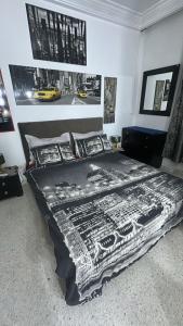 a bed in a bedroom with posters on the wall at self checkin in Tunis
