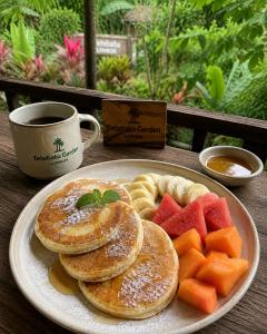 a plate of pancakes and fruit and a cup of coffee at Tetebatu Garden Lombok in Tetebatu +90 photos