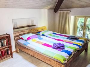 a bedroom with a large bed with a colorful comforter at Apartment Tazzino by Interhome in Locarno
