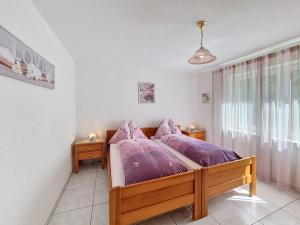 a bedroom with a bed with purple pillows at Apartment Luchre by Interhome in Zermatt