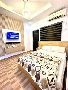 a bedroom with a bed and a flat screen tv at The Hideout in Lagos