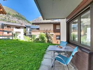 a table and chairs sitting on a patio with a yard at Apartment Luchre by Interhome in Zermatt