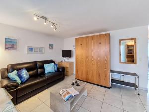 a living room with a leather couch and a cabinet at Apartment Luchre by Interhome in Zermatt