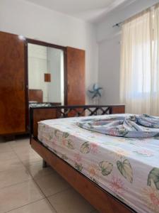 a bedroom with a bed with a floral blanket on it at AS Orikum 2 in Orikum