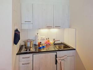 a kitchen with white cabinets and a sink at Apartment Chalet Schwendihus-11 by Interhome in Grindelwald