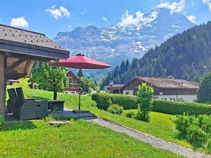 a patio with an umbrella and a table and chairs at Apartment Schwendihus by Interhome in Grindelwald