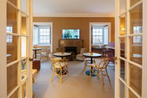 a room with tables and chairs and a fireplace at Villa Vasco da Gama in Cascais