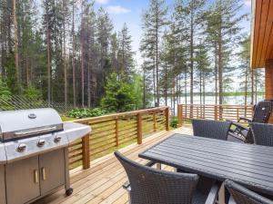 a deck with a grill and a table and chairs at Holiday Home Järvelä by Interhome in Kemijärvi