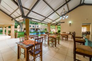 an open dining room with tables and chairs at Guest Paradise Lodge in Victoria Falls