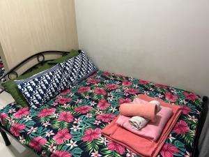 a bed with a flower patterned sheets and towels at Sea Residences in Manila +35 photos