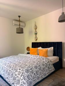 a bedroom with a black and white bed with orange pillows at Casa Saga proprietate administrata de o gazda particulara in Mangalia