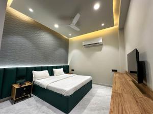 a bedroom with a bed and a flat screen tv at hotel fior in Pānīpat +19 photos
