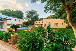a garden in front of a house at Guest Paradise Lodge in Victoria Falls