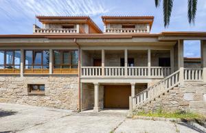 a large house with a balcony on top of it at A casa dos Viñedos, finca con piscina privada in Bayón