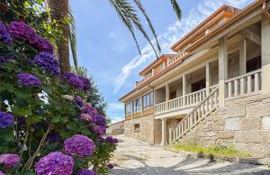 a building with purple flowers on the side of it at A casa dos Viñedos, finca con piscina privada in Bayón