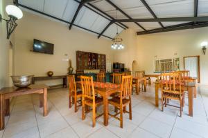 a dining room with wooden tables and chairs at Guest Paradise Lodge in Victoria Falls