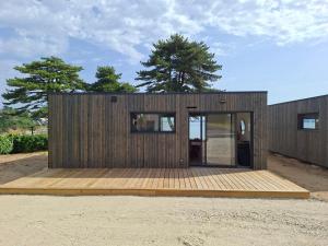 a small wooden house with a wooden deck at Le chalet Ker Yann Vue mer Locquirec in Locquirec