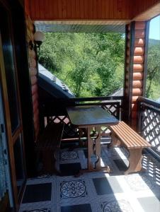 a screened in porch with a table and a window at Caдиба Ксенія in Sheshory