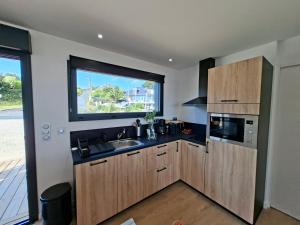 a kitchen with a sink and a window at Le chalet Ker Yann Vue mer Locquirec in Locquirec