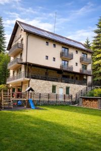 a large building with a playground in front of it at Transylvania Villa & Spa in Muntele Băişorii