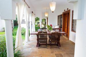 a dining room with a table and chairs on a patio at Beverly Suites - Two Bedroom Apartment 2-5min to Beach in Malindi