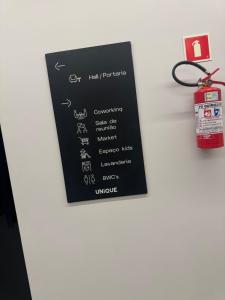 a black sign on a wall with a red tag at Flat no bairro universitário in Caruaru