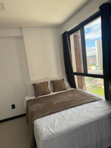 a bedroom with a bed and a large window at Flat no bairro universitário in Caruaru +18 photos