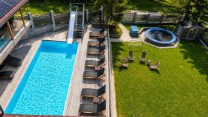 an overhead view of a swimming pool with lounge chairs and a swimming pool at Transylvania Villa & Spa in Muntele Băişorii