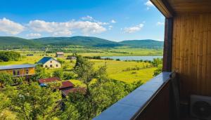 an outdoor balcony with a view of a farm and a lake at Bazaleti Hut in Bazalet'i