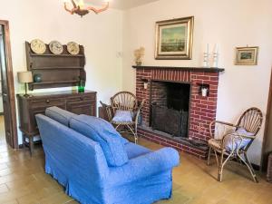 a living room with a blue couch and a fireplace at Holiday Home Nicol by Interhome in Trarego
