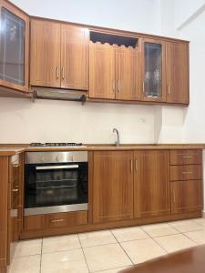 a kitchen with wooden cabinets and a stainless steel oven at AS Orikum 2 in Orikum +15 photos