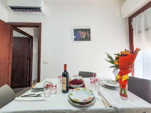 a table with a bottle of wine and a bowl of grapes at Holiday Home SinAgo by Interhome in Lascari