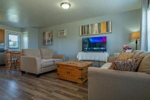 ein Wohnzimmer mit zwei Sofas und einem Fernseher in der Unterkunft Wood Duck Cottage in Cavendish