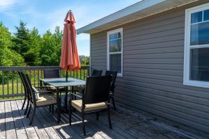 Ein Tisch und Stühle auf einer Terrasse mit einem Sonnenschirm in der Unterkunft Wood Duck Cottage in Cavendish