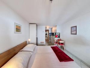 a large white bed in a room with a kitchen at Apartment Haus Bellevue-7 by Interhome in Zermatt +12 photos