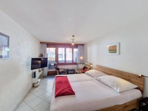 a bedroom with a large bed and a television at Apartment Haus Bellevue-7 by Interhome in Zermatt