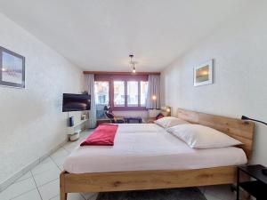 a bedroom with a large bed and a television at Apartment Haus Bellevue-7 by Interhome in Zermatt