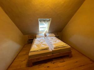a small bed in a small room with a window at Erbeskopf Gipfelquartier in Morbach