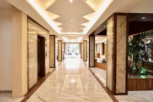 a hallway of a building with marble floors and ceilings at Hotel Maniratna Premium in Indore