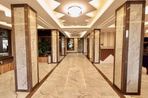a hallway of a hotel lobby with marble columns at Hotel Maniratna Premium in Indore
